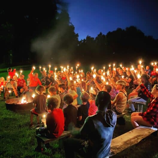 A group of kids holding torches at a summer camp in Iowa.