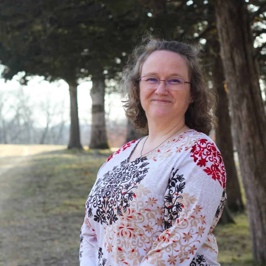Erin Kaye in front of the Cedar Trees at Deer Center