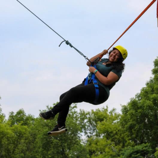 A girl on a zip line at a summer camp in Iowa.
