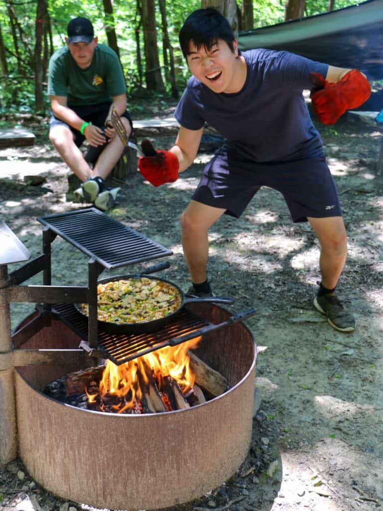 A campfire dinner in the Iowa woods at summer camp.
