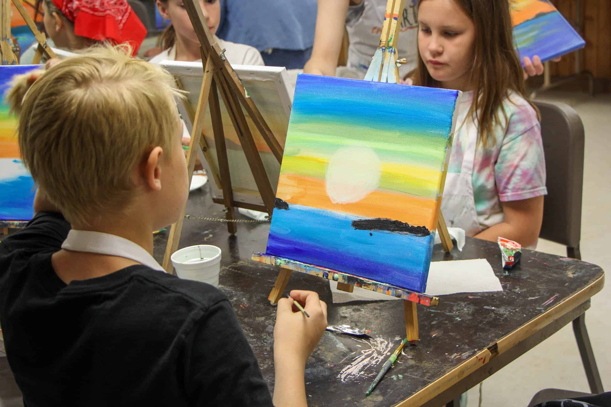 A group of kids painting at a summer camp in Iowa.