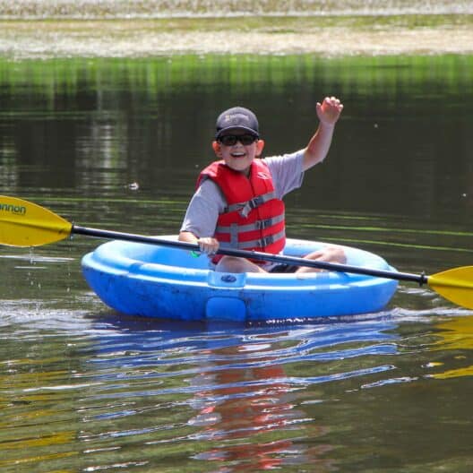 A boy at summer camp on a raft in Iowa.
