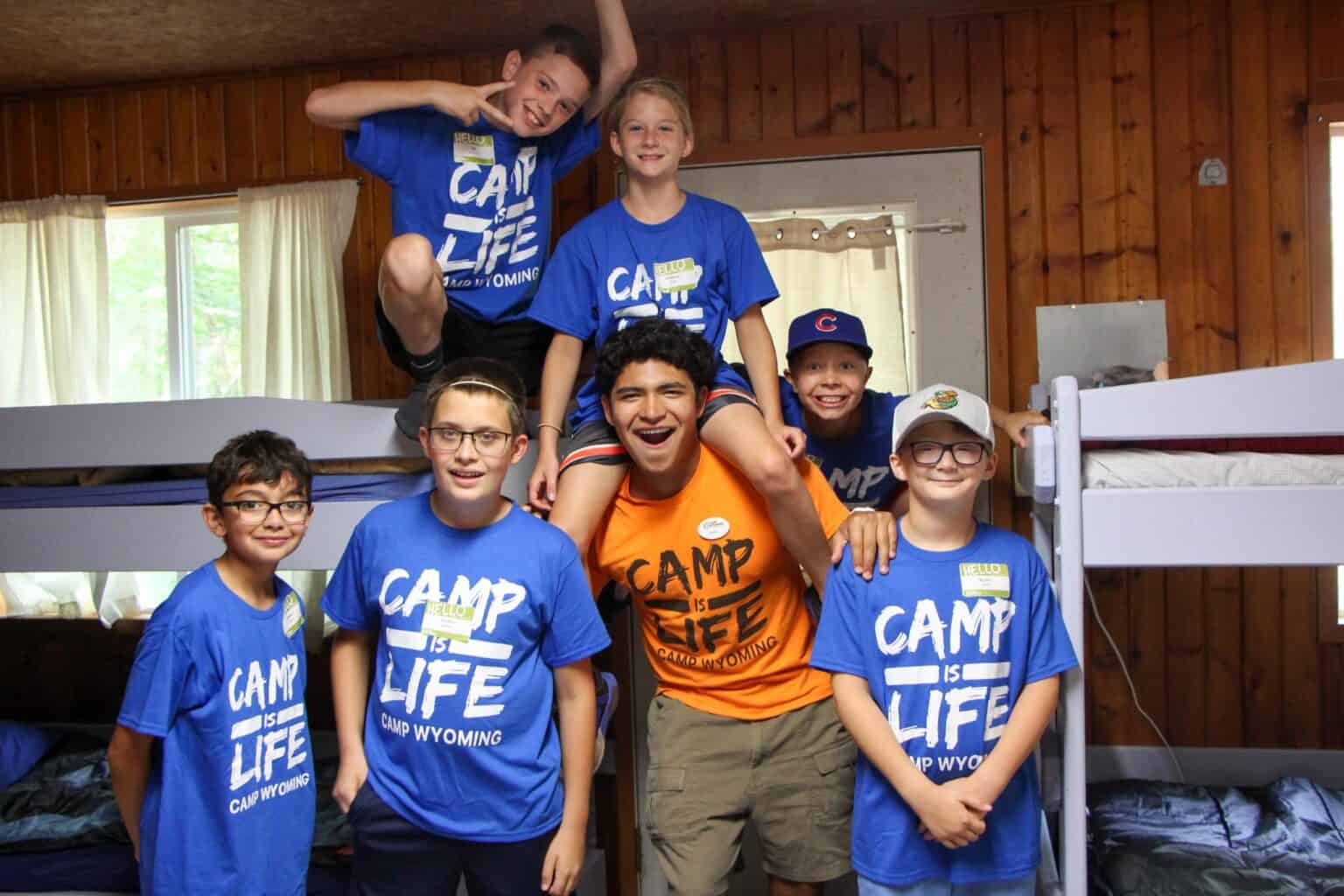 A group of kids posing for a picture in a bunk room at summer camp in Iowa.