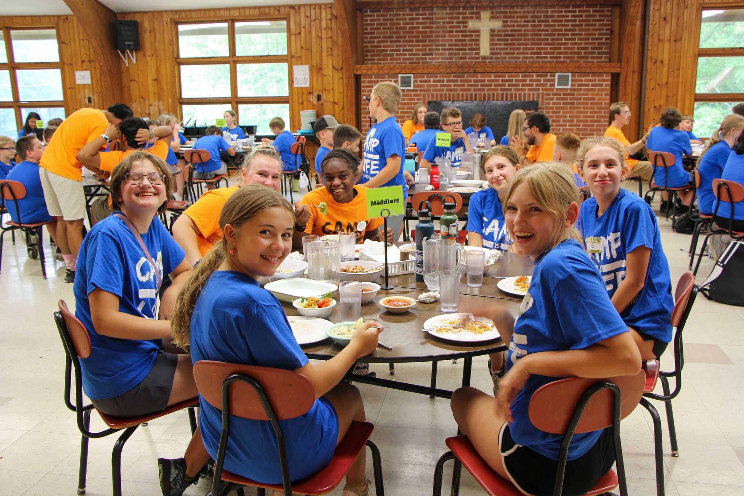 A group of kids sitting at a table during summer camp in Iowa.