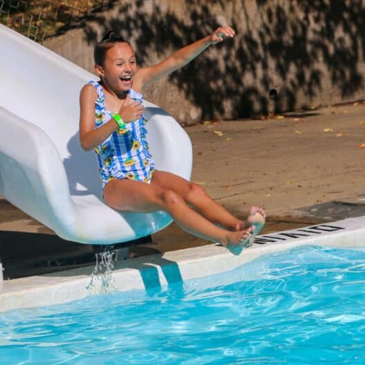 A girl enjoying a slide during summer camp in Iowa.