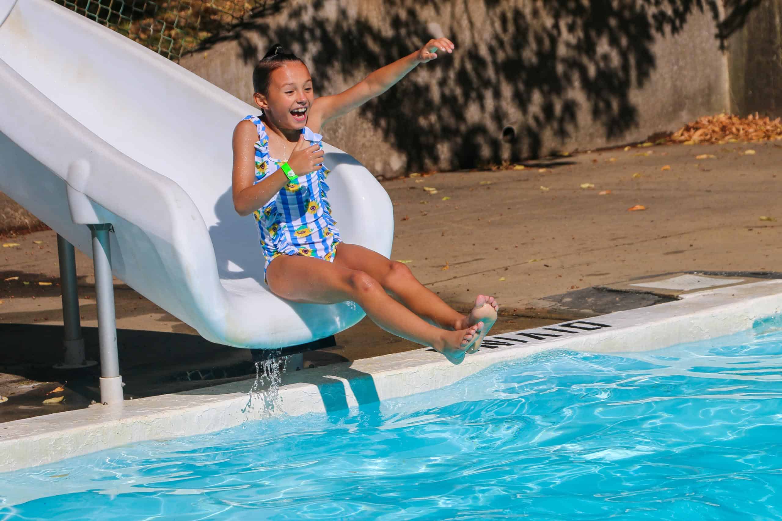 A girl enjoying a slide during summer camp in Iowa.