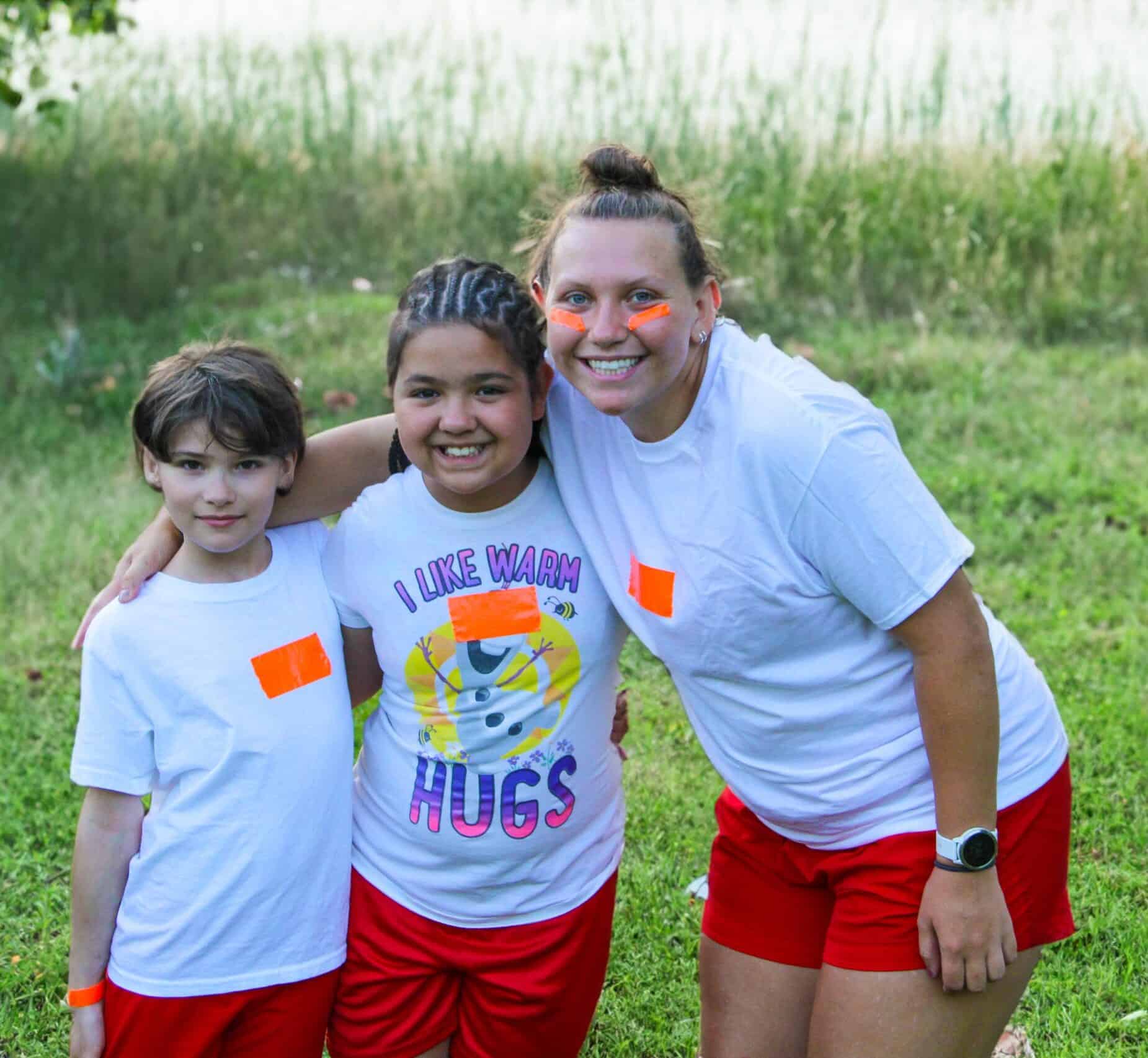 A woman and two kids pose for a photo in Iowa during summer camp.