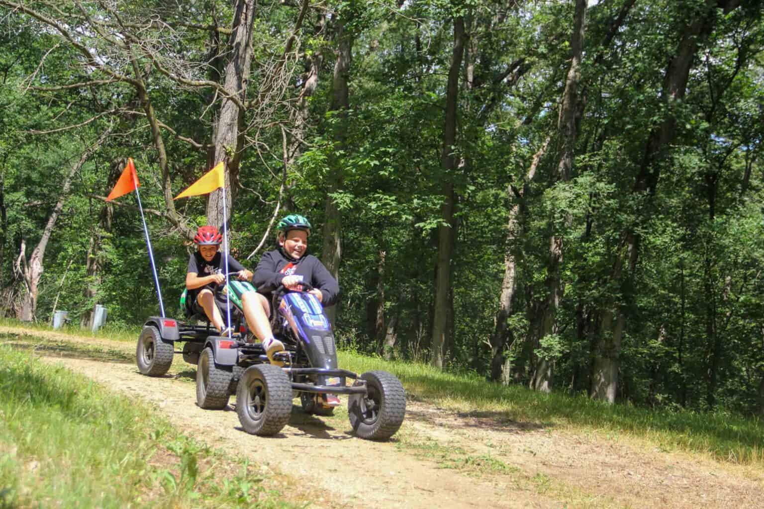 A group of kids riding a four wheeler at summer camp in Iowa.