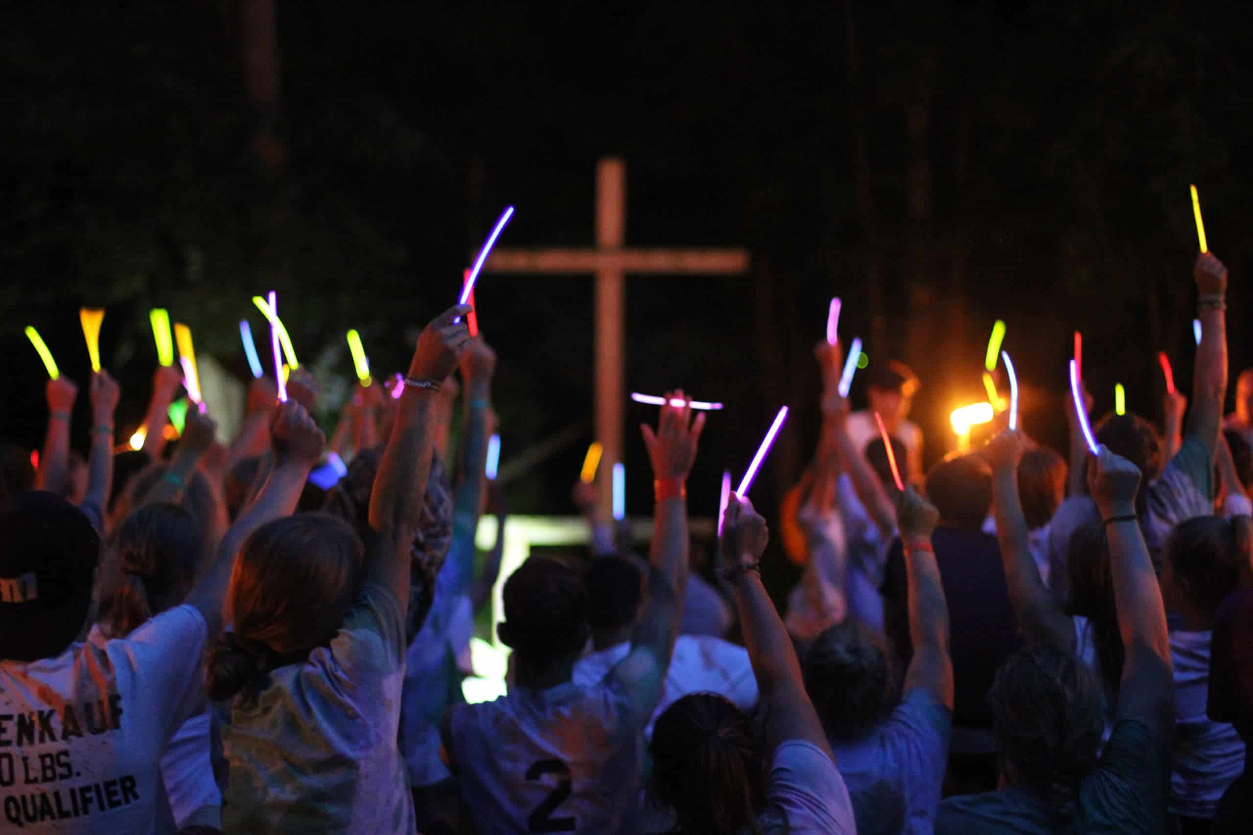 A group of kids holding up flashlights at a summer camp in Iowa.