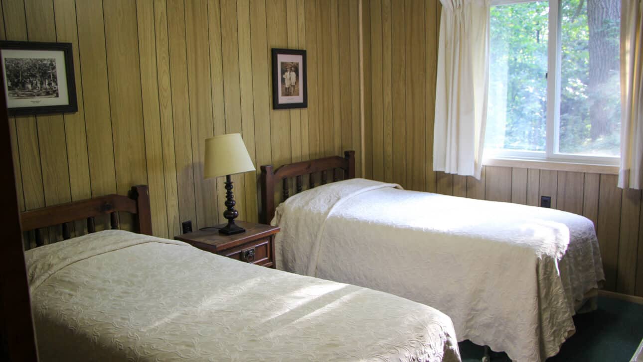 Two beds in a wood-paneled room at a summer camp in Iowa.
