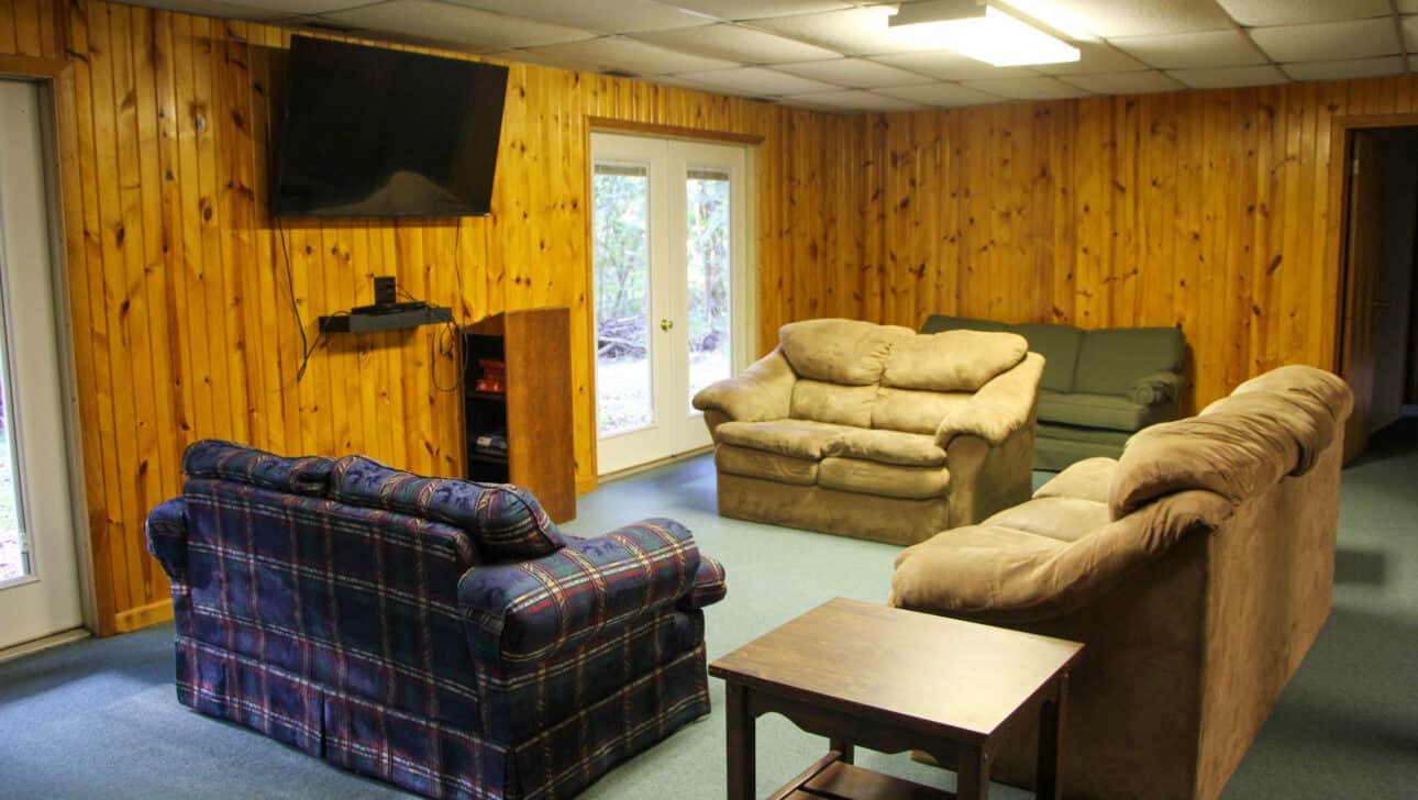 A summer camp living room with couches and a table in Iowa.